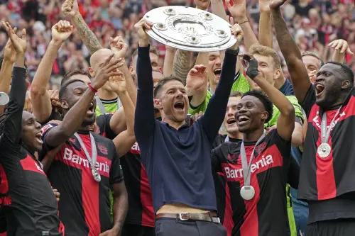 Leverkusen's head coach Xabi Alonso celebrates with the trophy as his team won the German Bundesliga, after the German Bundesliga soccer match between Bayer Leverkusen and FC Augsburg at the BayArena in Leverkusen, Germany. l Photo: AP