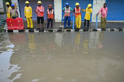 Men stand over a pavement along a flooded street after cyclone Michaung made landfall, in Chennai on December 3, 2023. Photo: AFP