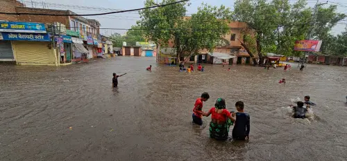 Fatehpur: Locals wade through a flooded area after heavy monsoon rains, in Fatehpur, Wednesday, July 5, 2023. (PTI Photo)