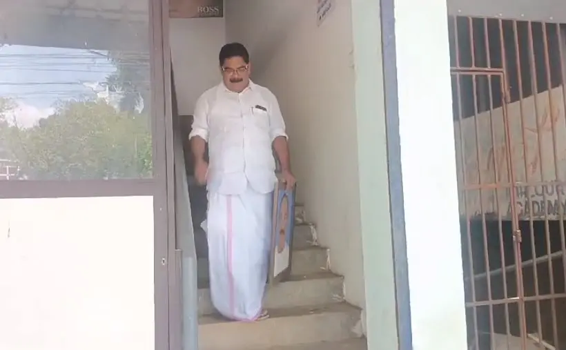 Saji Manjakadambil coming out of the KC(J) office at Pala carrying the framed photo of K M Mani | Photo:  Mathrubhumi