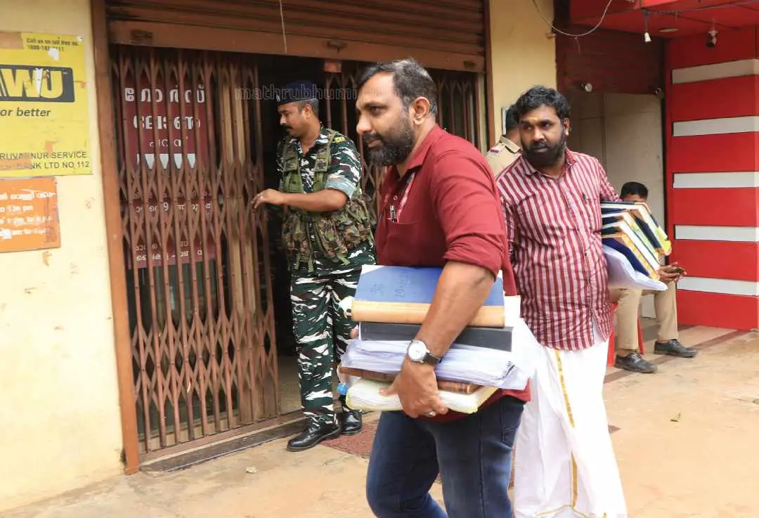 ED officers leaving the Karuvannur bank building with seized documents. (file photo)