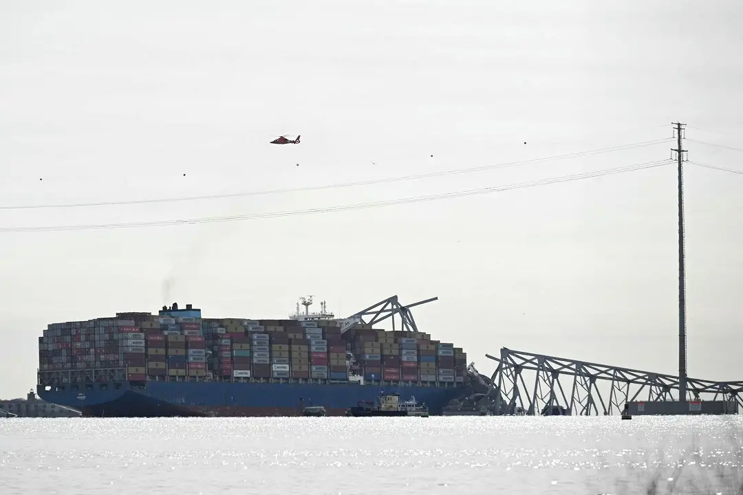 The steel frame of the Francis Scott Key Bridge lies in the water after it collapsed in Baltimore, Maryland | Photo: AFP