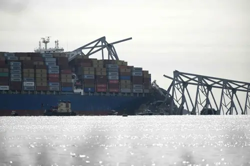 The steel frame of the Francis Scott Key Bridge sits on top of the container ship Dali after the bridge collapsed | Photo- AFP