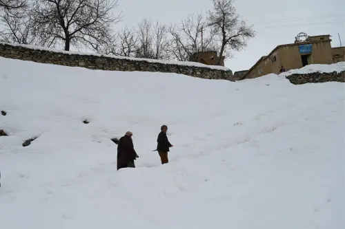 Afghan residents walk along a path during snowfall in Sarcheshma area in Behsud district of Maidan Wardak province. (Photo: AFP)