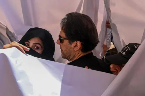 Former Pakistan Prime Minister Imran Khan (C) with his wife Bushra Bibi (L). (File Photo: AFP)