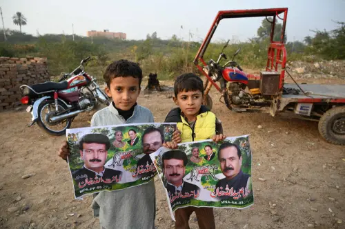 Children pose with election posters of Pakistan Muslim League Nawaz (PML-N) party candidates Obaidullah Khan Shadikhel and Amanatullah Khan Shadikhel in Mianwali, the native town of Pakistan's jailed former Prime Minister Imran Khan in Punjab Province.