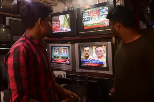 People watch a news television broadcast of the nomination of the next Pakistan's army Chief General Syed Asim Munir (on bottom R television 2R), at a market in Karachi on November 24, 2022. - Pakistan's government nominated on November 24 a former spymaster to be the next military chief, a position long considered the real power in the nuclear-armed Islamic nation of 220 million people. Photo: AFP