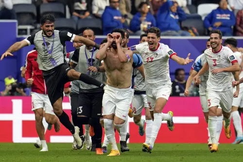 Syria's Omar Khrbin, without a shirt, celebrates with teammates after scoring during the Asian Cup Group B soccer match between Syria and India at Al Bayt Stadium in Al Khor, Qatar, on Tuesday. (Photo: AP)