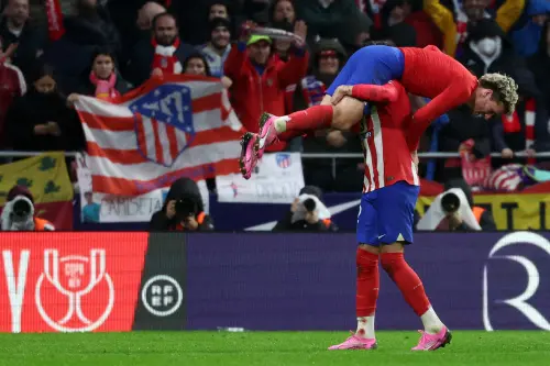 Atletico Madrid's French forward #07 Antoine Griezmann is lifted by Atletico Madrid's Uruguayan defender #02 Jose Gimenez after scoring his team's third goal during the Spanish Copa del Rey (King's Cup) football match between Club Atletico de Madrid and Real Madrid CF at the Metropolitano stadium in Madrid on January 18. Photo: AFP