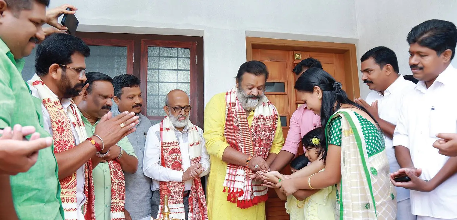 Lamp being lit by Suresh Gopi on Wednesday as Assam native Munmi Gogoi and her family moved into the new house named 'Sreelakshmi' | Photo: Mathrubhumi