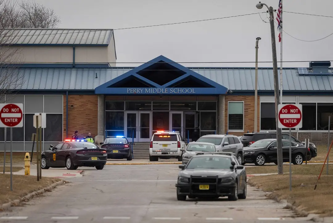 Police officers secure the campus at Perry Middle and High School during a shooting situation in Perry | Photo: AFP