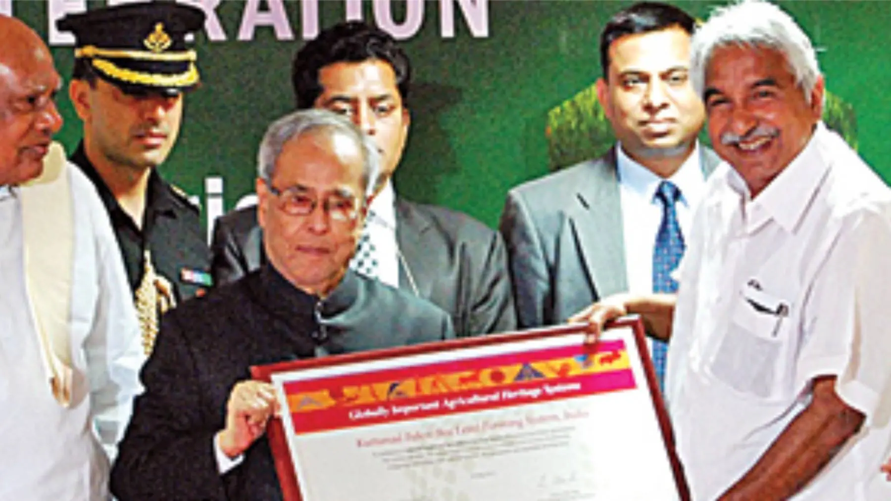 Photograph taken in 2012, in which MS Swaminathan and Oommen Chandy can be seen holding he United Nations plaque recognizing Kuttanad as a 'Global Agricultural Heritage Zone'.