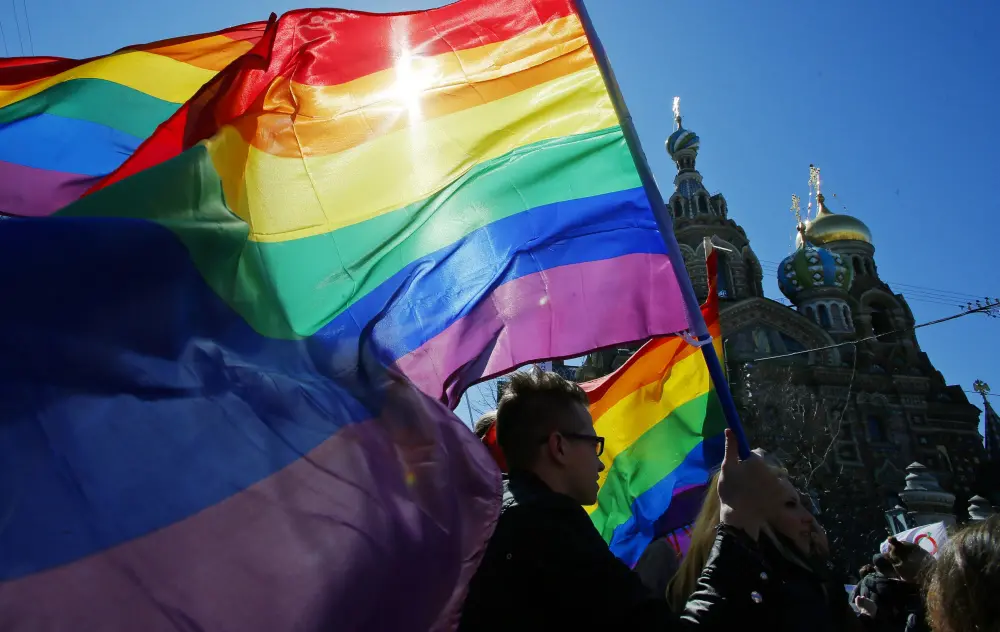 Gay rights activists carry rainbow flags as they march during a May Day rally in St. Petersburg, Russia | AP
