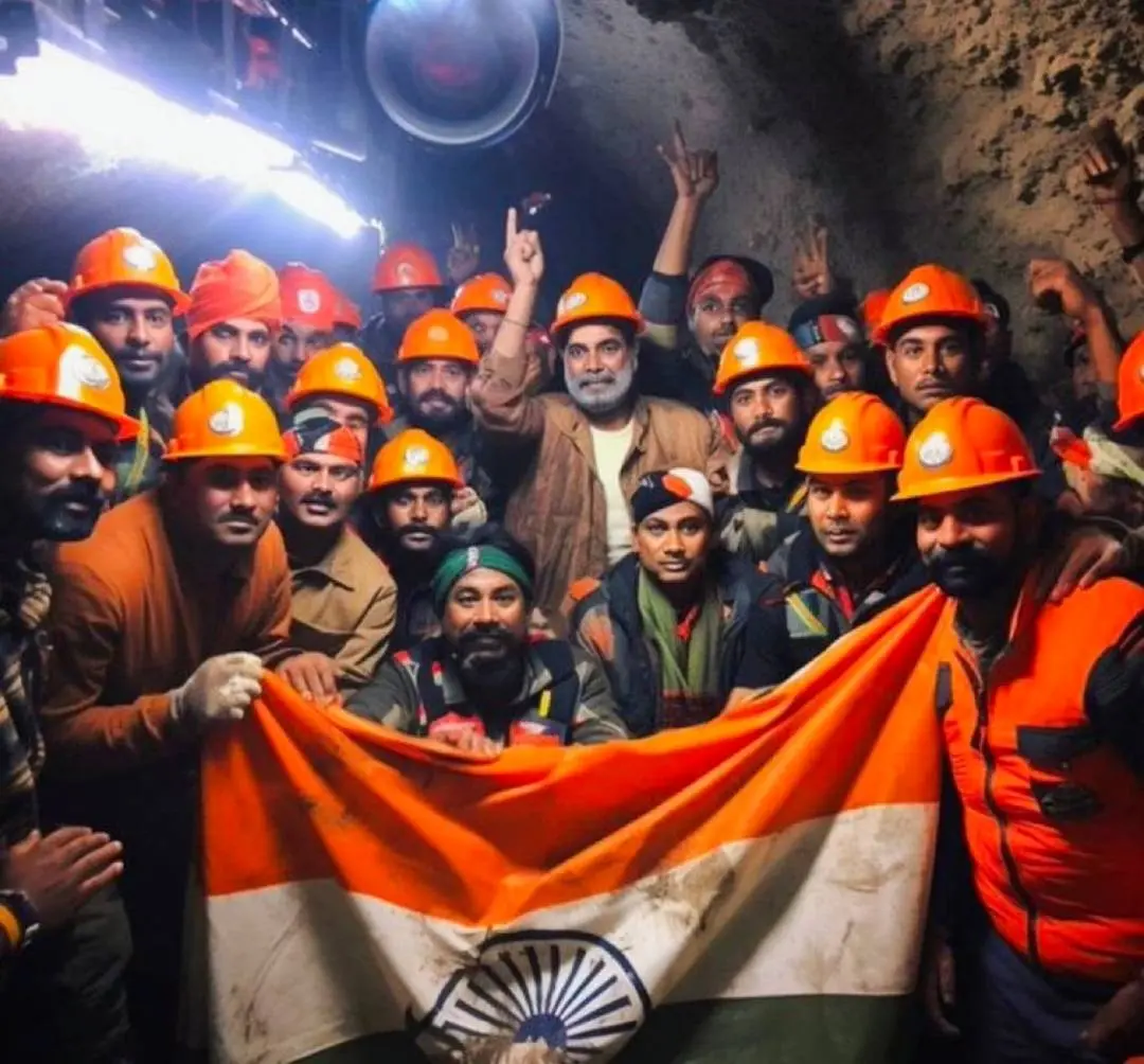 Rescue officials pose for group photos after the successful evacuation of 41 workers from the collapsed Silkyara Tunnel, in Uttarkashi district