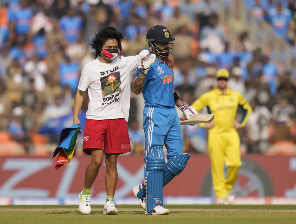 A spectator wearing a t-shirt saying 'Stop Bombing Palestine' runs on to the pitch | AP