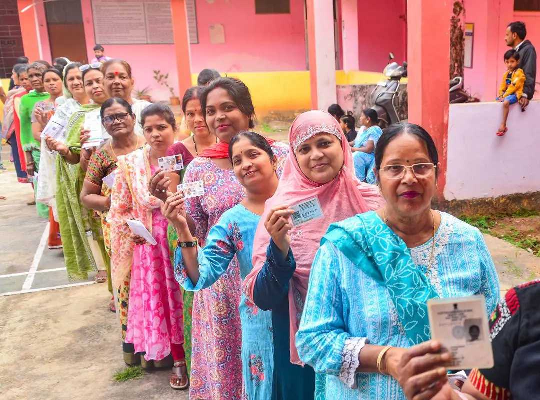 Voters show their identification cards as they wait in a queue to cast their votes for the 1st phase of Chhattisgarh Assembly elections