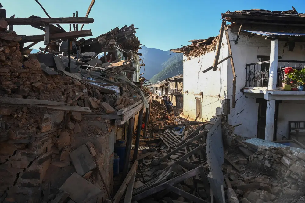 Residents walk amid the rubble of damaged homes in Jajarkot district | AFP