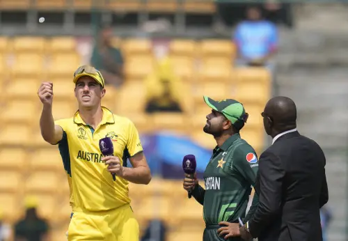 Australia's captain Pat Cummins tosses the coin as Pakistan's captain Babar Azam watches at the start of the ICC Men's Cricket World Cup match between Australia and Pakistan in Bengaluru, India, Friday, Oct. 20, 2023. Photo: AP