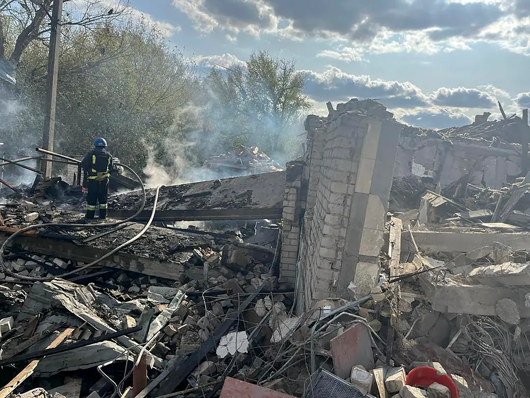 Firefighters work to extinguish a fire after the deadly Russian rocket attack that killed more than 40 people in the village of Hroza near Kharkiv | Photo: AP