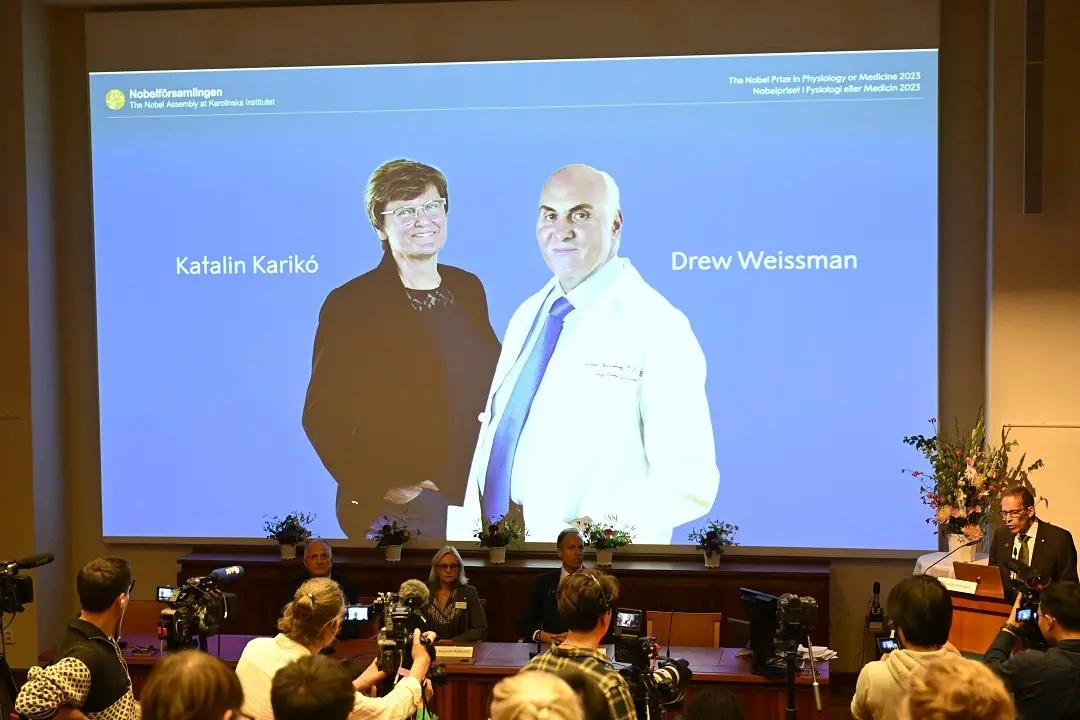 Thomas Perlmann, secretary of the Nobel Assembly, right, announces the winner of the 2023 Nobel Prize in Physiology or Medicine to Katalin Karikó and Drew Weissman, seen on screen, at the Karolinska Institute in Stockholm | Photo: AP