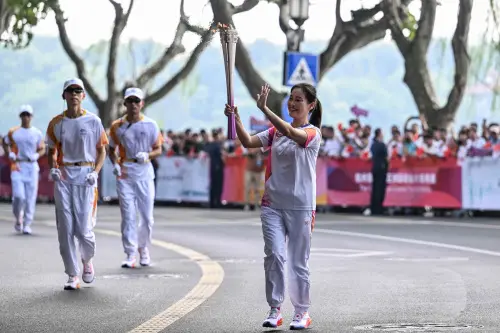 Jiaxing Ye, a traditional Chinese ceramist, runs during the Asian Games torch relay in Hangzhou, in China's eastern Zhejiang province on September 8, 2023 | Photo: AFP