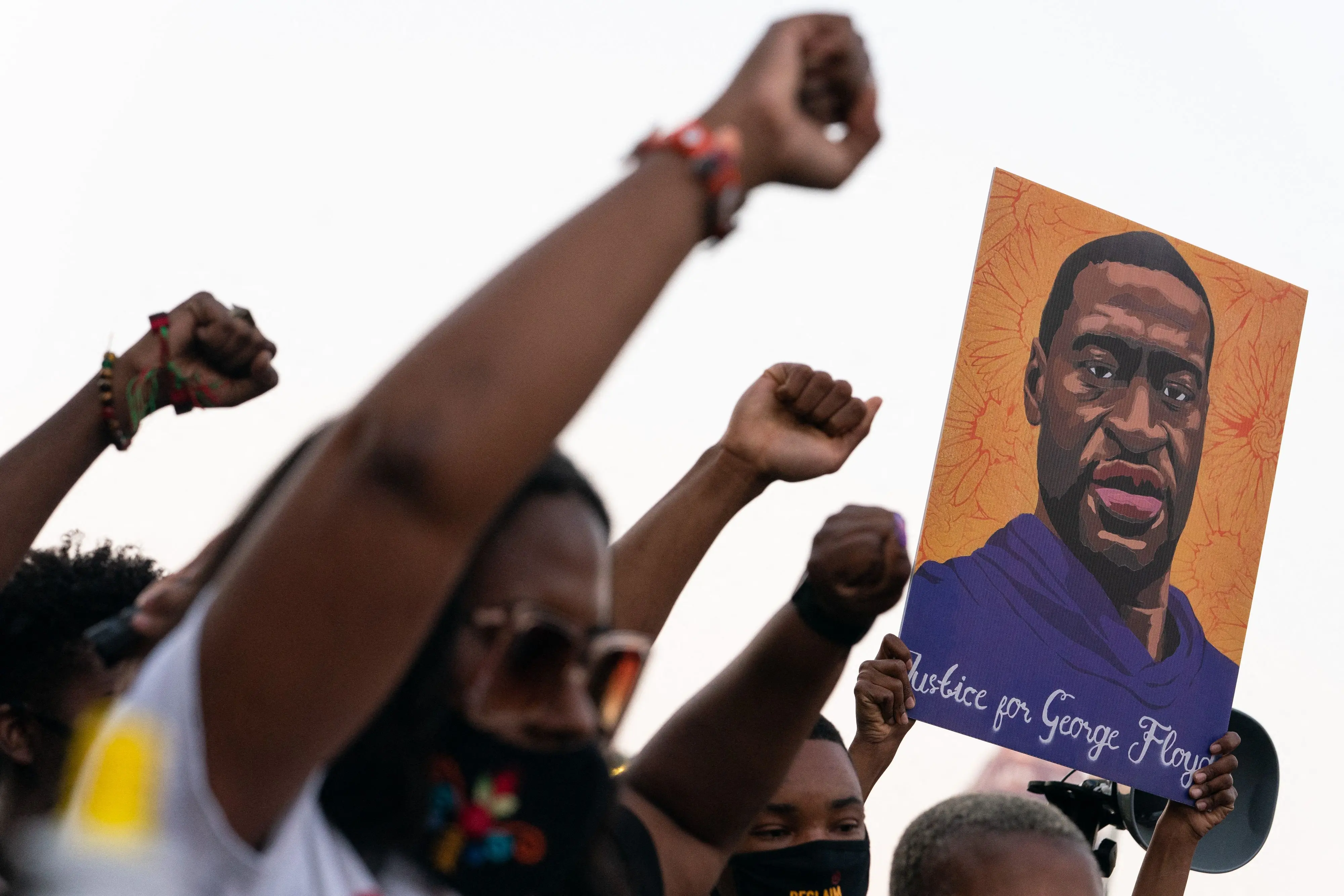 People protesting with portrait of George Floyd | Photo: AFP