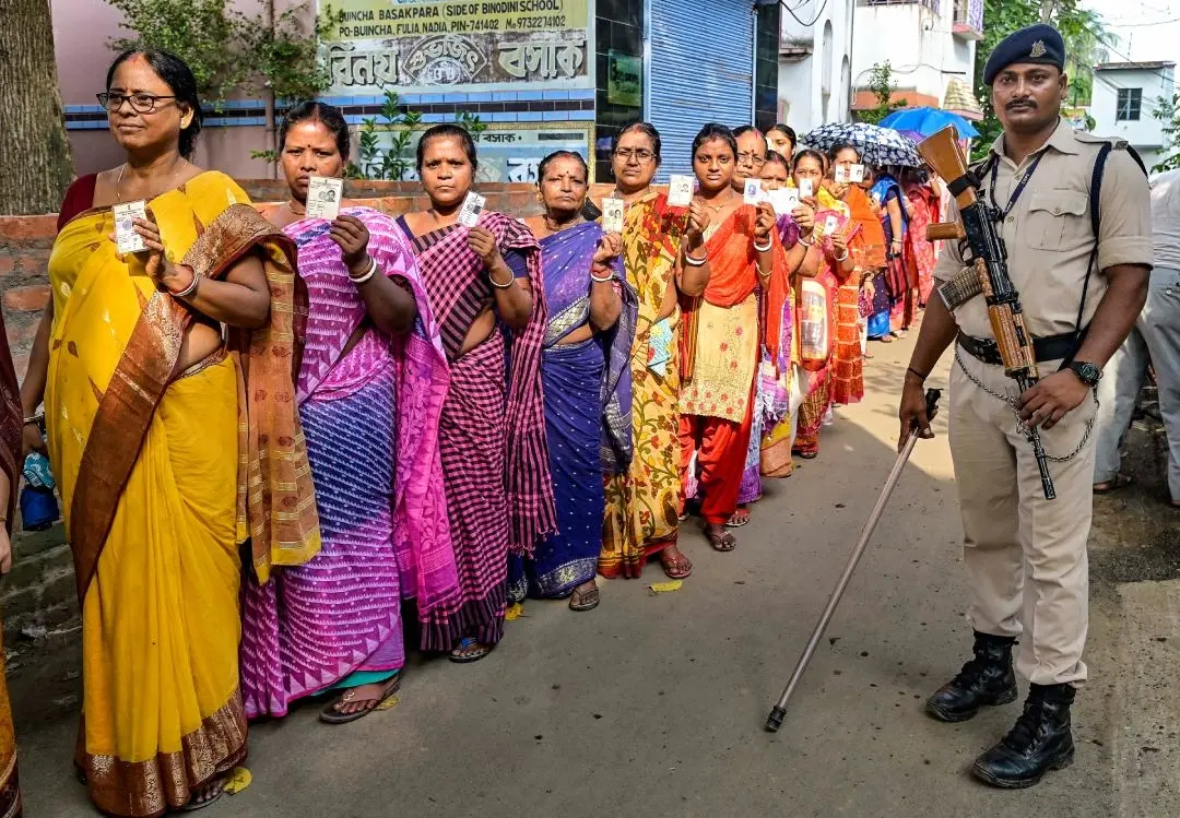 A CISF paramilitary jawan guards as people wait to cast their votes at a polling booth during panchayat repolls in Nadia district of West Bengal | Photo: PTI