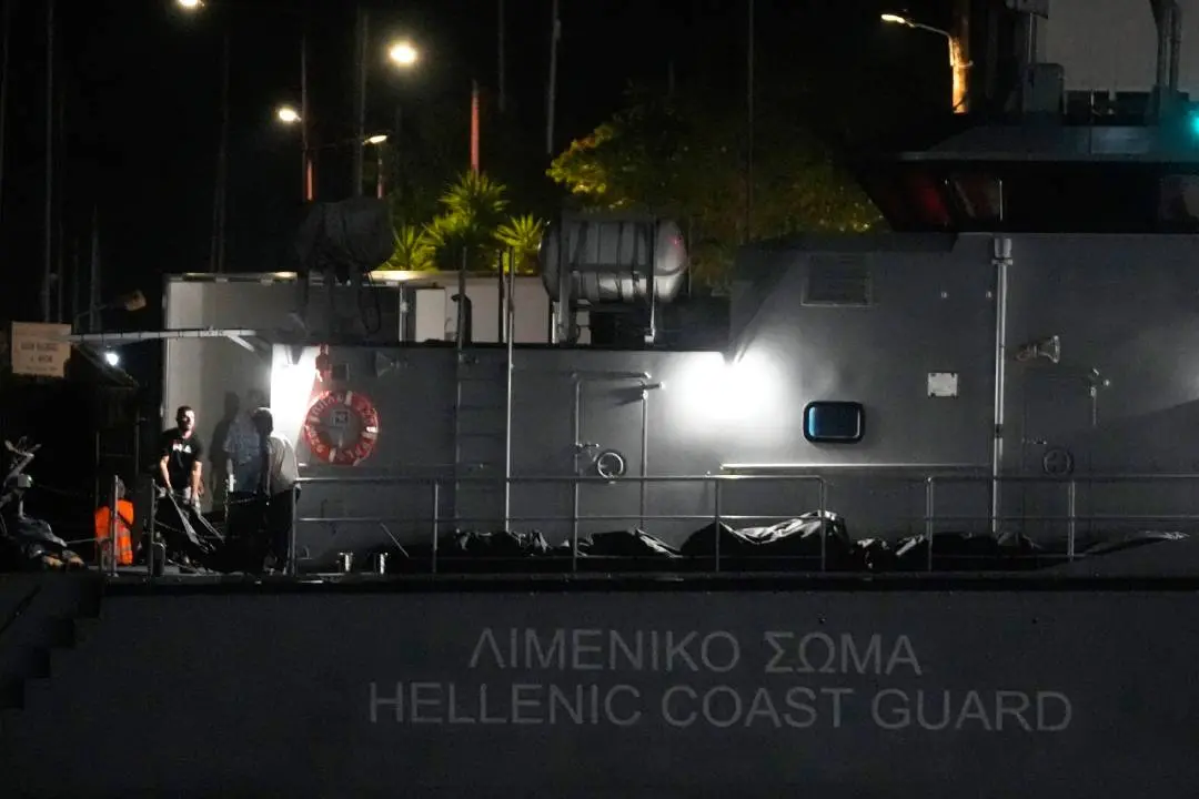 Rescue workers carry bodies from a coast guard vessel to a refrigerated truck at the port in Kalamata town, late Wednesday, June 14, 2023 | Photo: AP