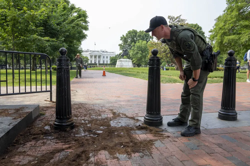 Police officer inspects a security barrier | AP