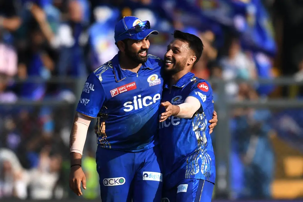 Akash Madhwal (R) is congratulated by his team captain Rohit Sharma | AFP