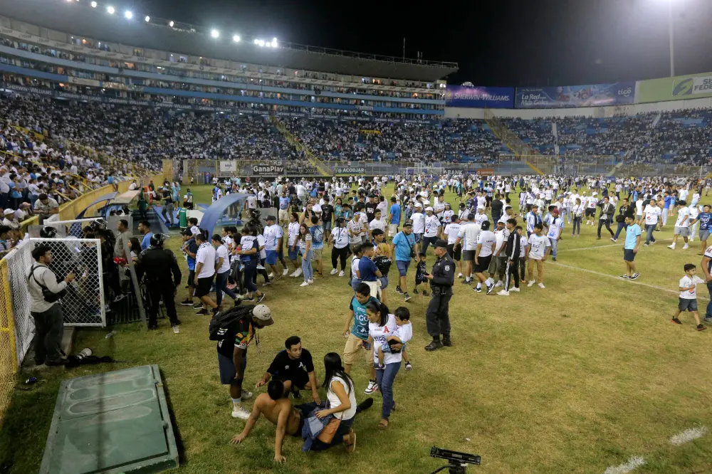 Supporters are helped by others following the stampede | AFP