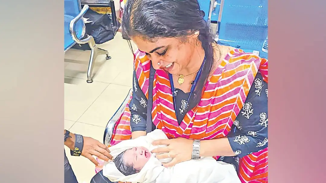 Maya VS Nair with the woman's baby | Photo: Mathrubhumi