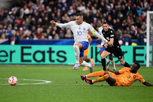 Kylian Mbappe (L) fights for the ball with Netherlands' defender Lutsharel Geertruida (R) | AFP