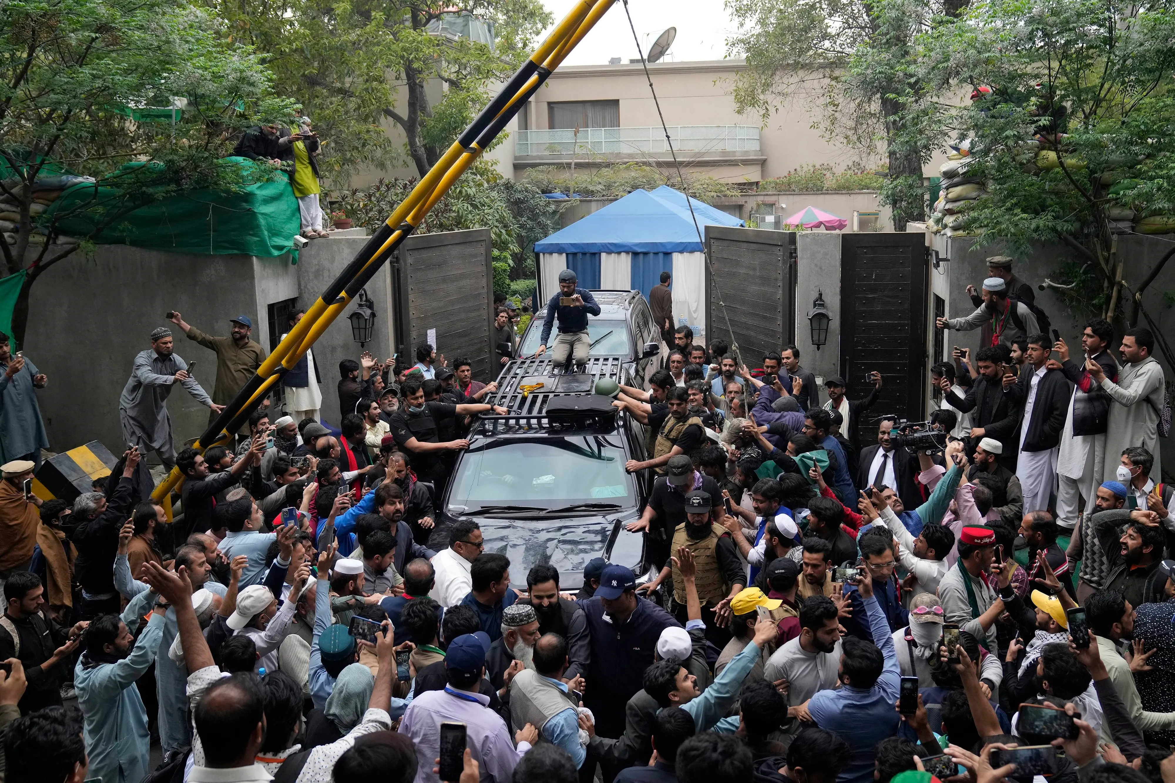 A vehicle carrying former Prime Minister Imran Khan is surrounded by his supporters as he leaves for Islamabad from his residence in Lahore | Photo: AP
