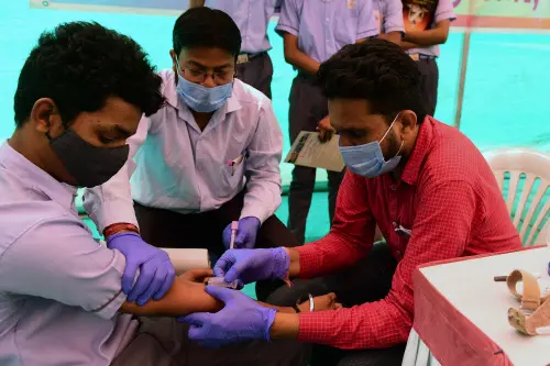 A health worker (R) collects blood sample from a school student for health checkup as a precaution against the H3N2 virus | AFP