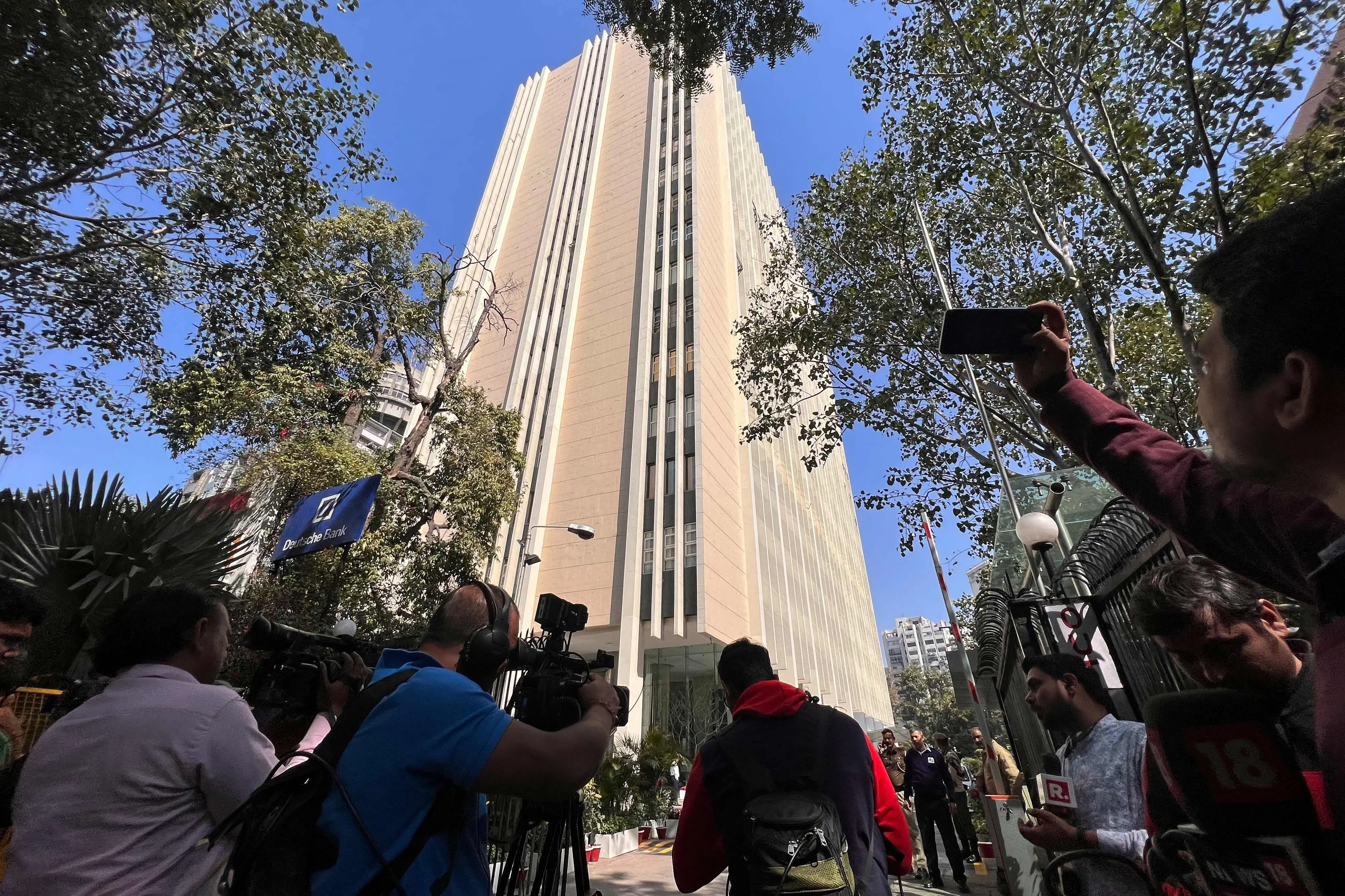 Members of the media report from outside the office building where Indian tax authorities raided BBC's office in New Delhi / File Photo: AFP