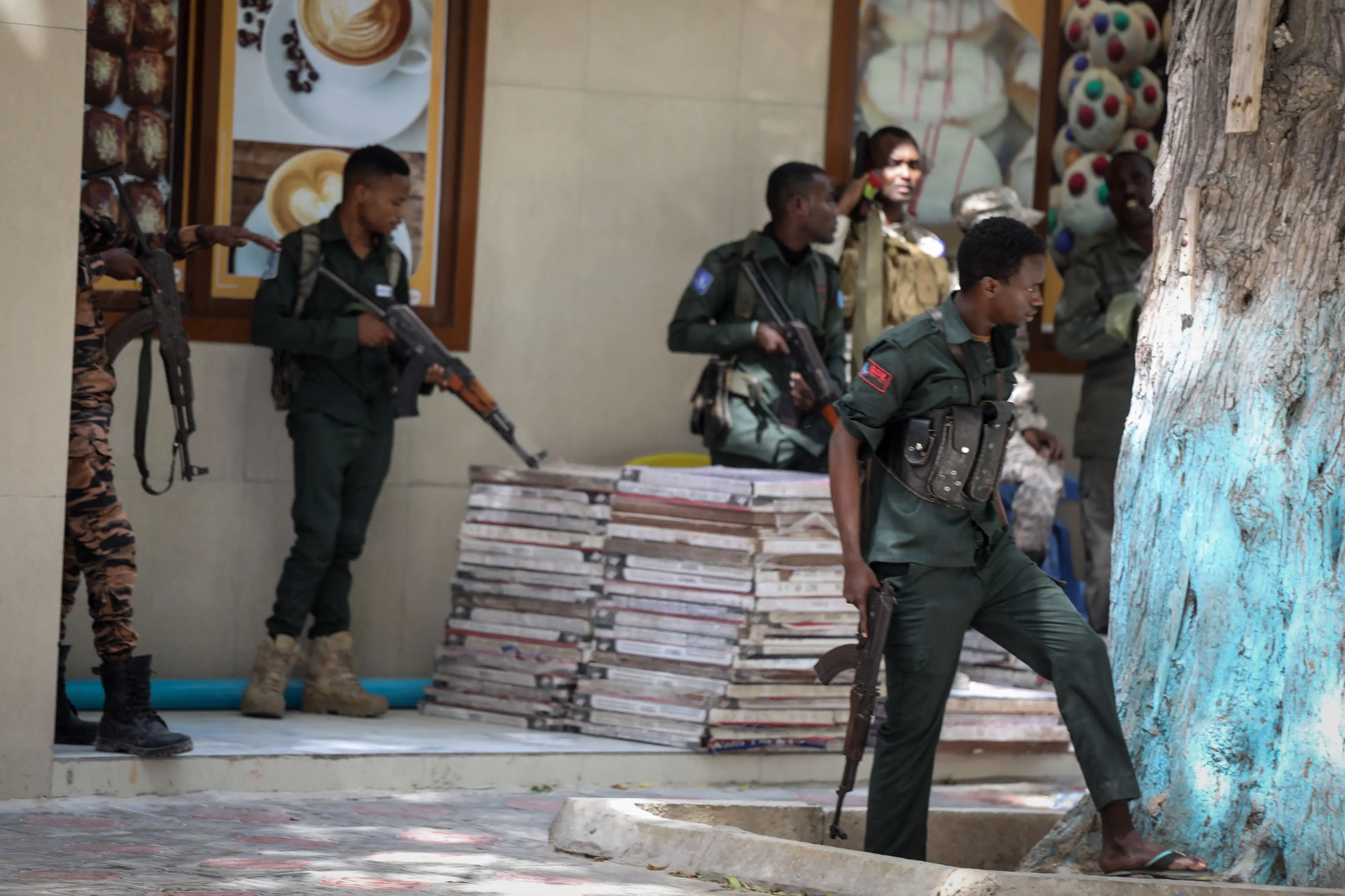 Police officers take up positions outside of the Mayor's office where an ongoing gun battle erupted following a reported explosion, in Mogadishu / Photo: AFP