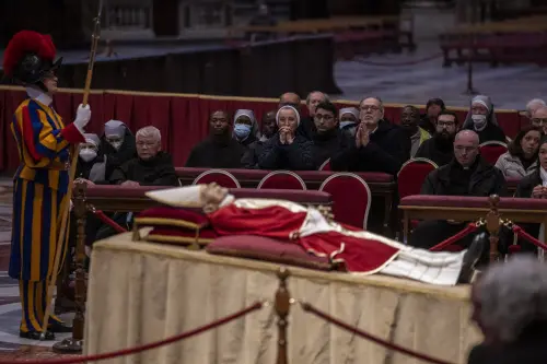 Mourners view the body of Pope Emeritus Benedict XVI as it lies in state inside St. Peter's Basilica at The Vatican where thousands went to pay their homage Monday, Jan. 2, 2023. The Vatican announced that Pope Benedict died on Dec. 31, 2022, aged 95, and his funeral will be held Thursday, Jan. 5, 2023 | Photo: AP