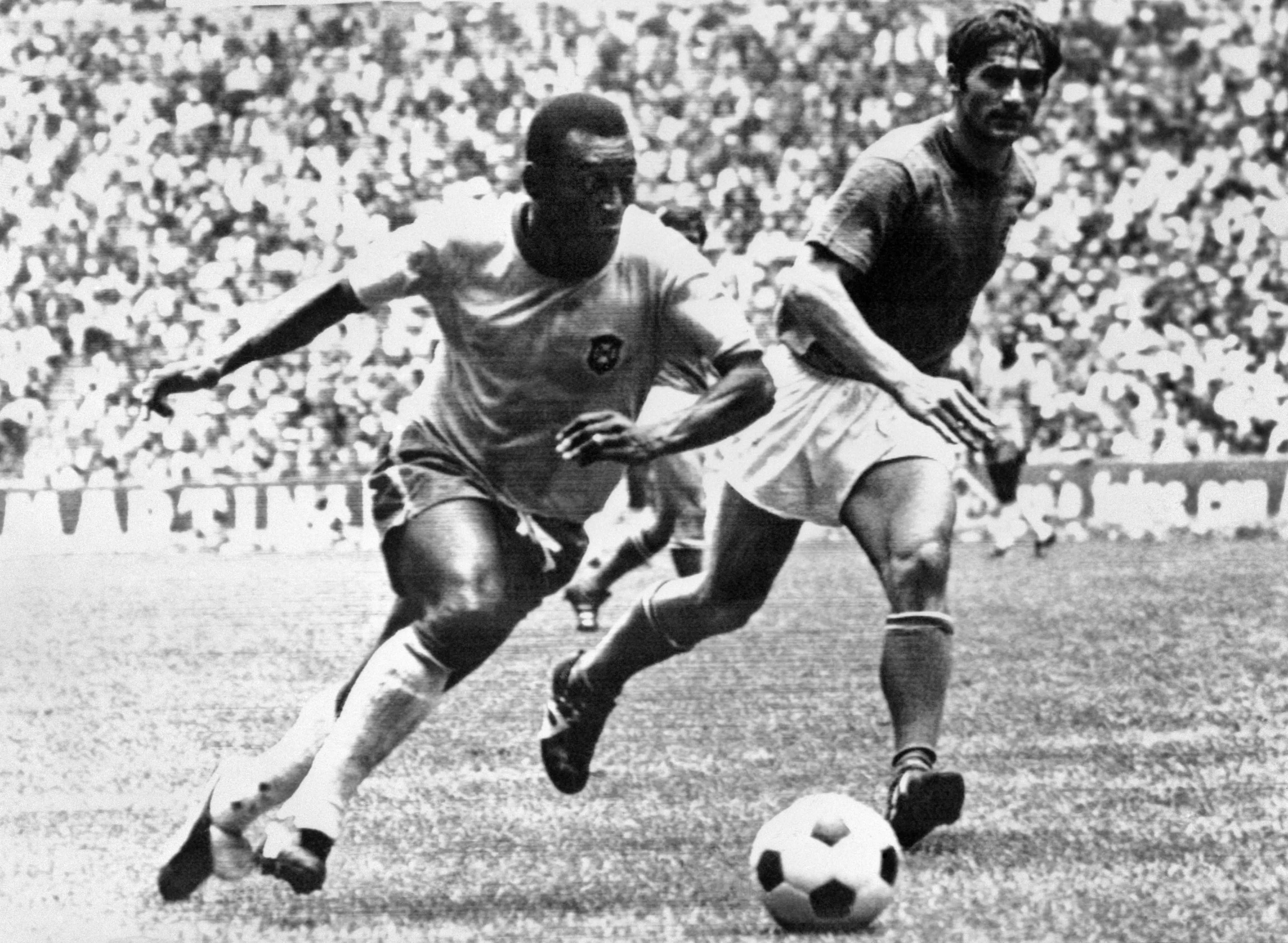 Pele (L) dribbling past Italian defender Tarcisio Burgnich during the World Cup final | AFP