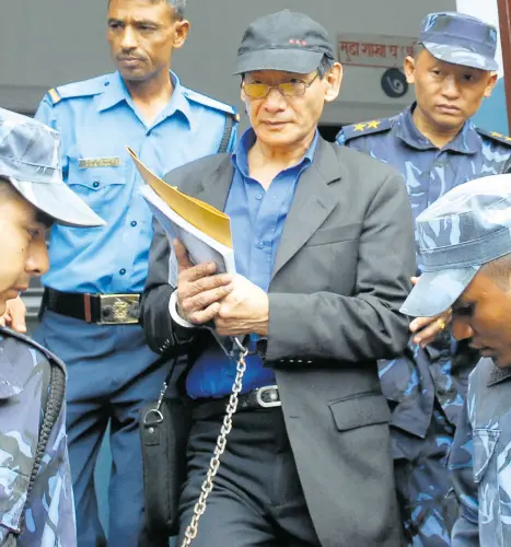 French serial killer Charles Sobhraj (C) is guided by Nepalese policemen towards a waiting vehicle after a court hearing in Kathmandu | Photo: AFP
