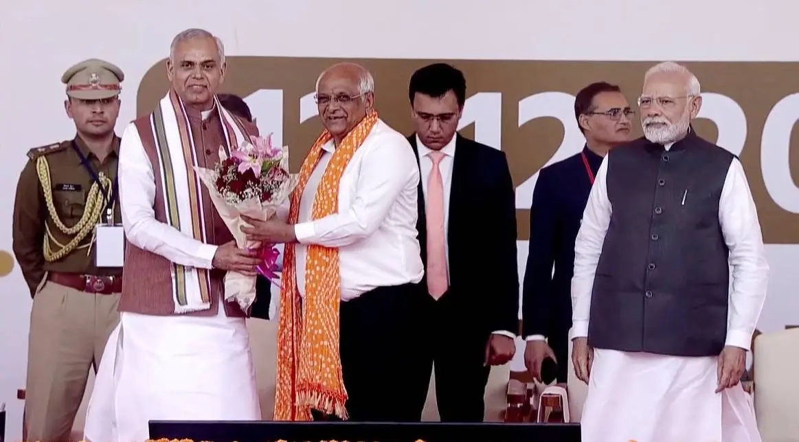Gujarat Governor Acharya Devvrat presents a bouquet to BJP leader Bhupendra Patel during the latter's oath-taking ceremony as Gujarat Chief Minister, in Gandhinaga