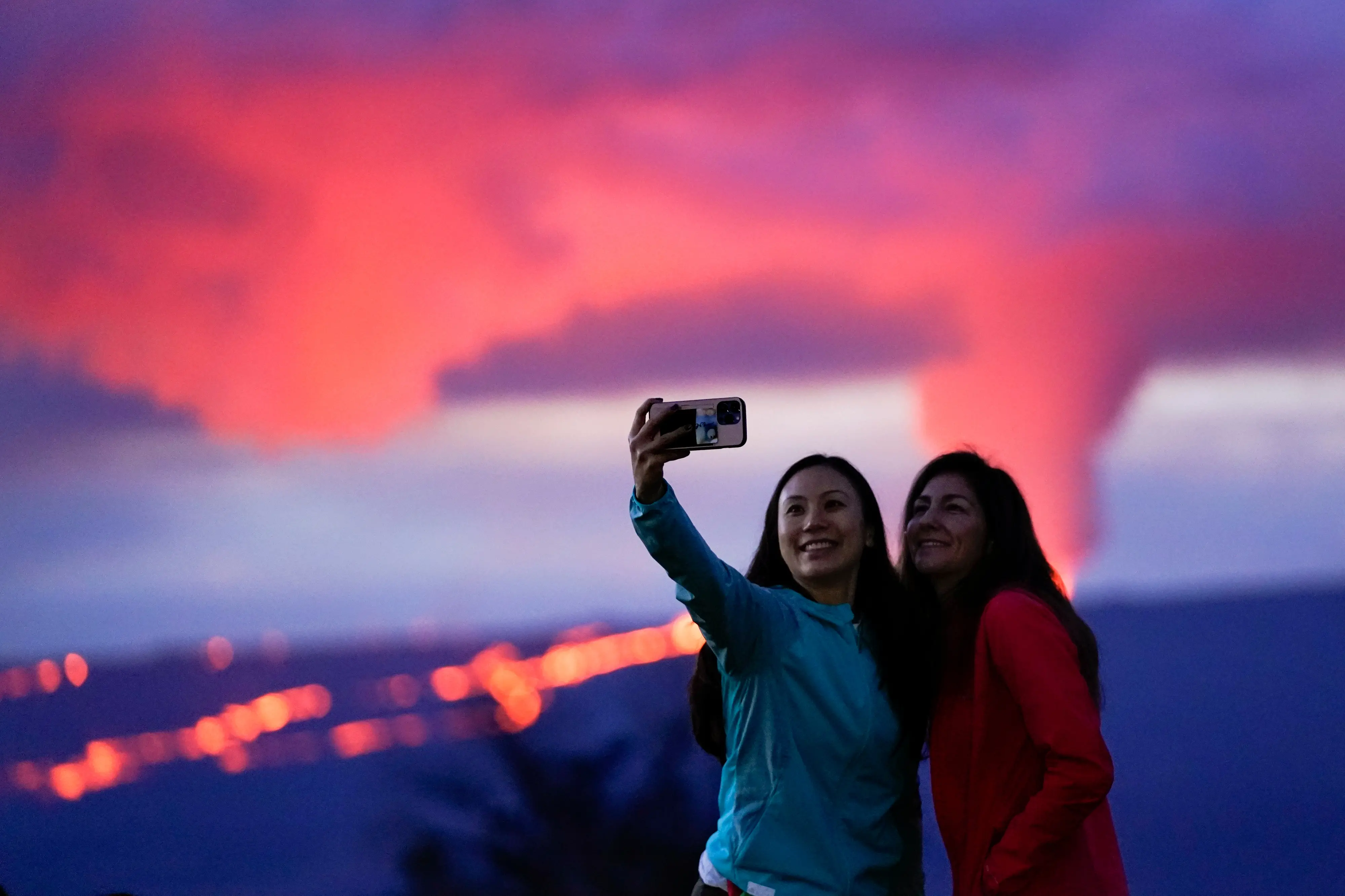 Tourists take a photo in front of lava erupting from Hawaii's Mauna Loa volcano I Photo: AP