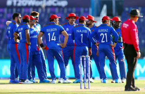 Afghanistan players wait for a pending decision during the ICC Men's T20 World Cup match between Afghanistan and Namibia at Sheikh Zayed stadium in Abu Dhabi on Sunday. (ANI Photo)