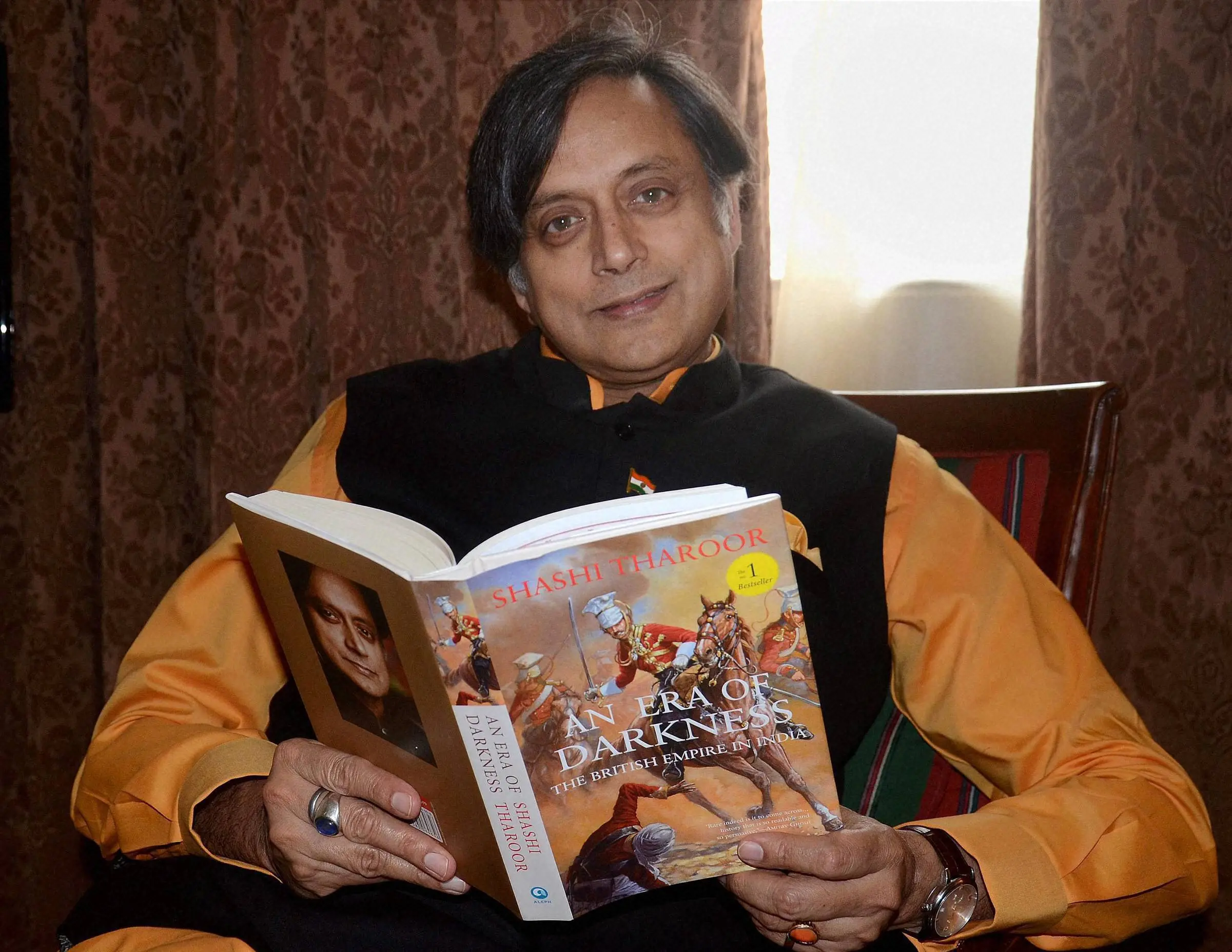 Congress leader Sashi Tharoor with his book 'An Era of Darkness' . Photo: PTI