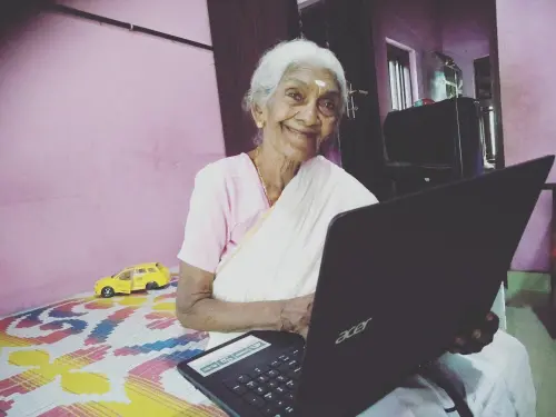 Karthyayani Amma from Haripad, first-rank holder in 'Aksharalaksham' examination by Literacy Mission, with the laptop presented by the then education minister C Raveendranath. File photo | Mathrubhumi