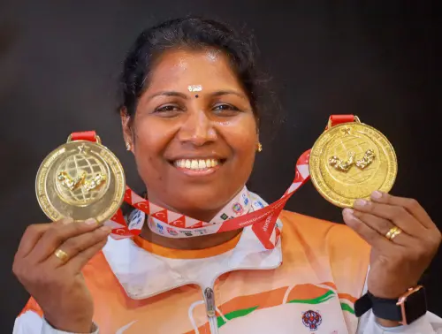 Kerala policewoman Mini Raju, ASI, poses with her gold medals won during the World Arm-Wrestling Championship in Turkey, on her arrival in Kozhikode, Monday, Oct. 31, 2022 | Photo: PTI