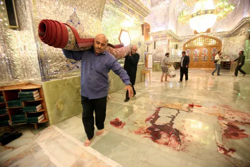 Workers clean up the scene following an armed attack at the Shah Cheragh mausoleum in the Iranian city of Shiraz on October 26, 2022. - At least 15 people were killed in an attack on a key Shiite Muslim shrine in southern Iran, state media said, with the Islamic State group claiming the assault. The attack carried out by an armed 'terrorist' during evening prayers at the Shah Cheragh mausoleum also wounded at least 19 people, state television said | Photo: AFP