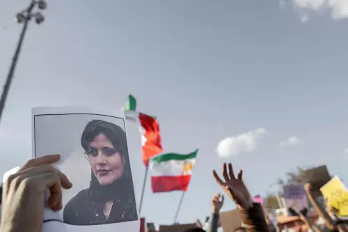 A protestors holds a photo of Kurdish Iranian woman Mahsa Amini | Photo: AFP