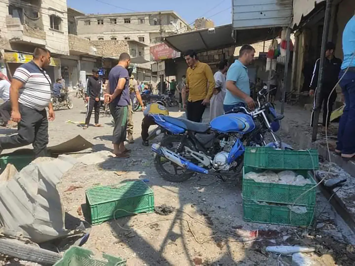 Syrian residents check a market the attacked by rockets, at al-Bab town, north Syria / Photo: AP