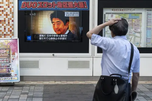 A man looks at a television broadcast showing news about the attack on former Japanese prime minister Shinzo Abe earlier in the day, along a street of Tokyo on July 8, 2022. - Shinzo Abe was shot at a campaign event in the city of Nara on July 8, a government spokesman said, as local media reported the nation's longest-serving premier was showing no vital signs | Photo: AFP
